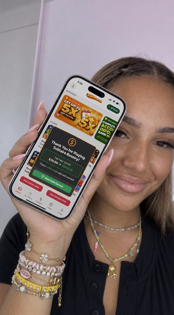 Player holding phone showing ZipRewards cash earned